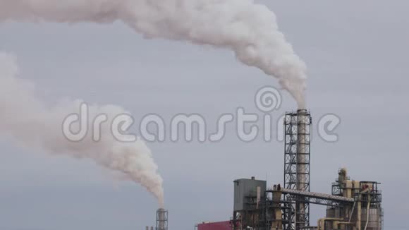 工业区用一根管道冒厚的白烟与太阳形成对比从工厂管道中倒出污染视频的预览图