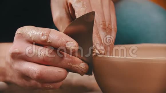 陶器主人正在用一一个特殊的铲子来光滑粘土碗的表面视频的预览图