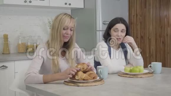 白种人女人端着苹果坐在盘子前眼巴巴地看着一个金发碧眼的瘦小朋友闻起来很香视频的预览图