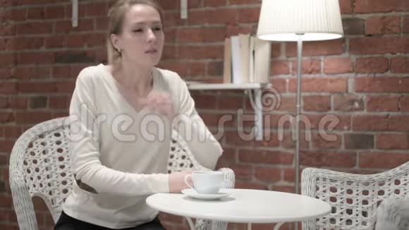 有魅力的年轻女人喝咖啡和咳嗽视频的预览图