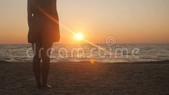 一对浪漫的年轻夫妇站在海滨的剪影男人走过来牵着女孩手一起享受阳光视频的预览图