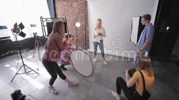 时装表演由一组摄影师在专业摄影棚里用一个漂亮的模特为一个光滑的视频的预览图