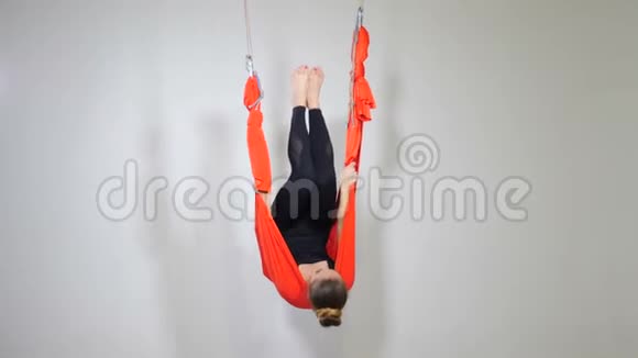 运动的女人倒吊在吊床工作室漂亮女孩在白色背景下练习反重力瑜伽视频的预览图