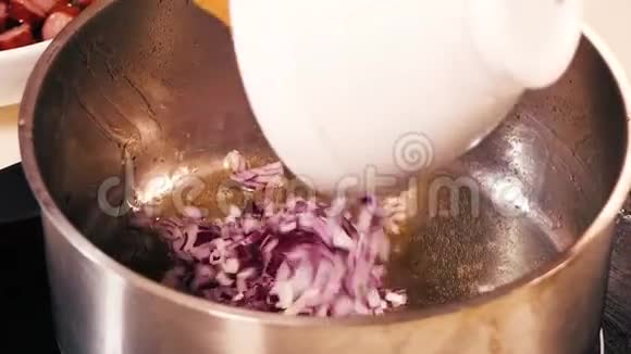 从碗中取出的红洋葱被转移到一个大的搪瓷锅中然后混合视频的预览图