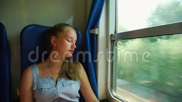 漂亮的女孩睡在靠近窗户的火车上微笑着视频的预览图