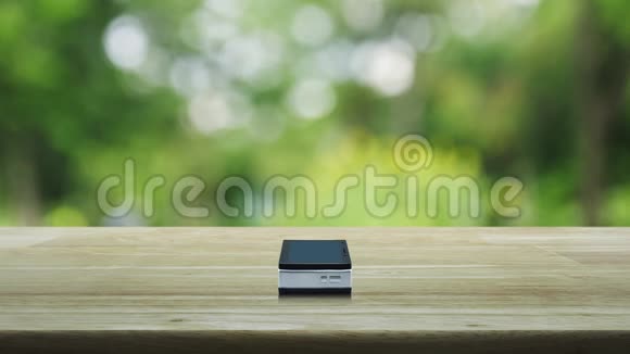 在公园绿树模糊的木桌上现代智能手机屏幕上的24小时服务图标商务全职在线视频的预览图