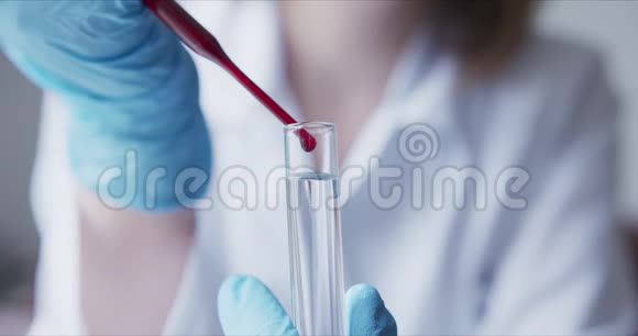 用吸管分析红色液体提取DNA的科学家视频的预览图