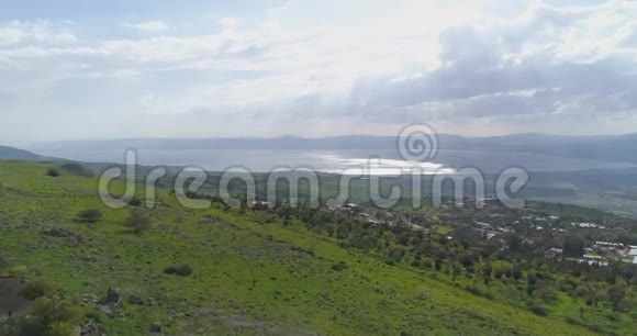 在以色列北部的戈兰高地和泰伯里亚上空的空中射击开阔的田野上面有绿色的风景和群山视频的预览图