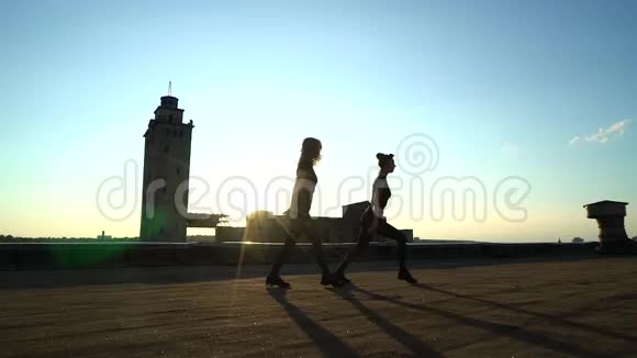 日落时分女孩成双成对地在屋顶上跳舞视频的预览图