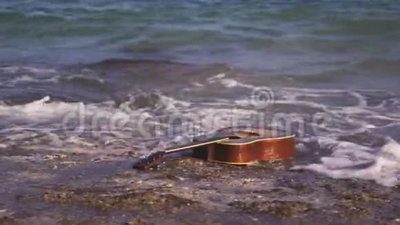 吉他在蓝色的蔚蓝的水中漂浮漂浮在大海或海洋的波浪上西吉他游泳游泳漂流漂浮视频的预览图