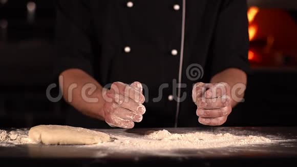 这家餐馆厨师把他那双沾满面粉的手拍在一起面粉慢慢地碎在桌子上视频的预览图
