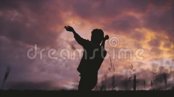 一位留着短发的年轻女子在夏天黄昏的田野里独自跳舞视频的预览图