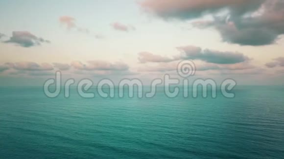 日落时蓝色平静的海浪和多云的天空4k视频视频的预览图