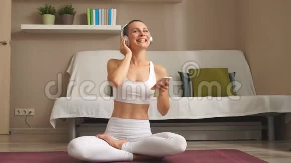 白种人年轻的短发女人微笑喜欢坐在灯光室的垫子上视频的预览图