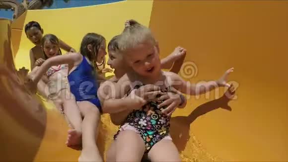 一群快乐的孩子骑在橙色的滑梯上视频的预览图
