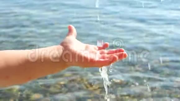 幼儿的手在玩水水滴落在孩子的手上概念性健康儿童旅行概念视频的预览图