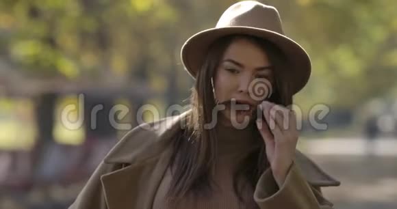 年轻可爱的欧洲女孩戴着优雅的帽子摘下太阳镜摇动她棕色的长发魅力视频的预览图