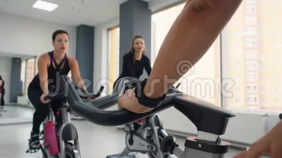 运动男女一起在健身房骑自行车视频的预览图