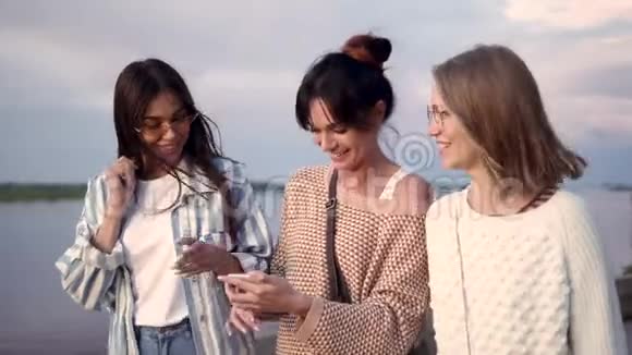 快乐的女性朋友在智能手机上进行语音搜索笑着看着结果视频的预览图