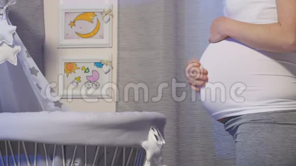 准妈妈站在婴儿床旁边视频的预览图