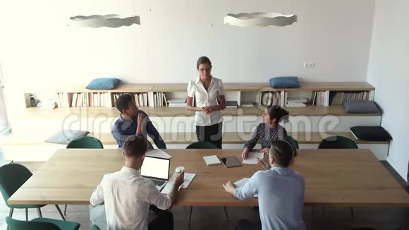 不同的员工聆听团队领导聚集在会议室的上方视频的预览图