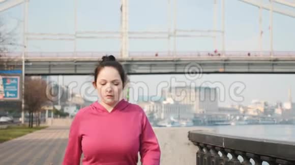 在河边和城市桥上进行北欧步行训练的迷人女士的前跟镜头健康概念视频的预览图