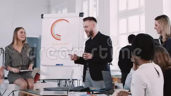 快乐微笑的中年商务教练在现代轻办公室工作场所与团队交谈慢动作红色EPICW视频的预览图