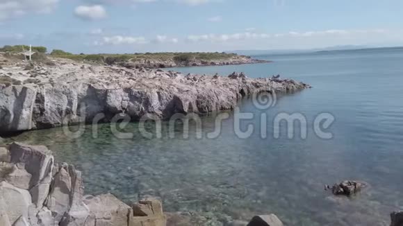 靠近岩石湾的白色吊床有晶莹剔透的水和峭壁视频的预览图