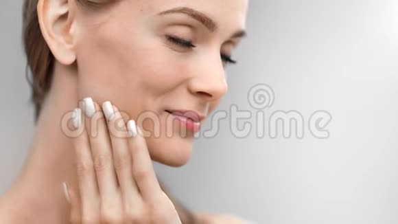 近距离皮肤面部微笑女性用手指触摸享受健康的皮肤科护理结果视频的预览图