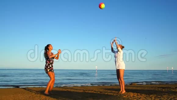体育女游客日落时在沙滩上打排球视频的预览图