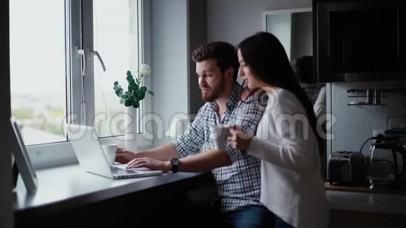 有胡子的年轻人在笔记本电脑屏幕上向女孩展示他的作品视频的预览图