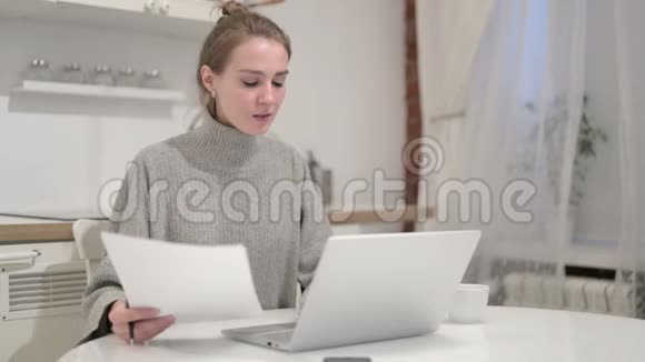 青年妇女在家阅读文件视频的预览图