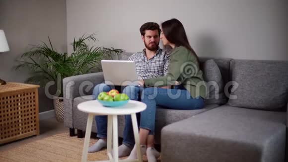 可爱积极的年轻夫妇用笔记本电脑做电子商务网上购物视频的预览图