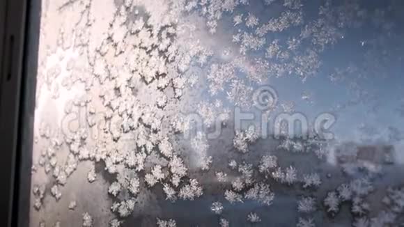 在金色初升的太阳下霜冻的窗表上美丽的冰花闪闪发光视频的预览图