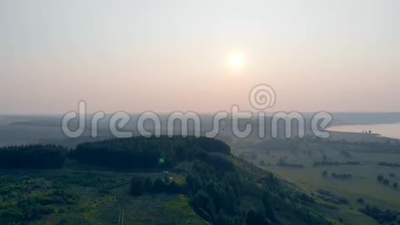 一个人带着滑翔机在空中飞过田野空中滑翔伞视频的预览图