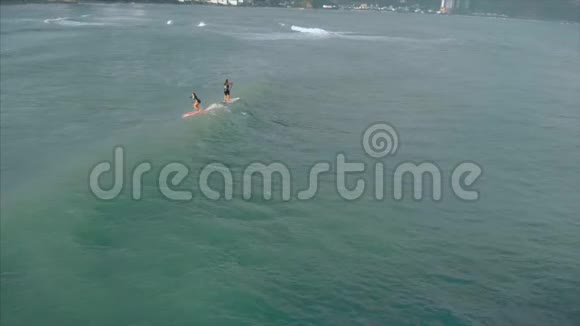 从上面的运动青年男女冲浪乘坐大浪与明亮的日光冲浪者正在等待他视频的预览图