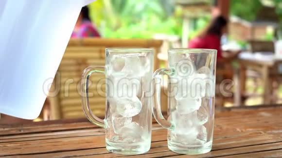 把水倒入装有冰的玻璃杯里在炎热的天气里喝一杯简单的提神饮料视频的预览图