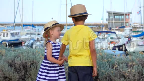 男孩和女孩手牵着游艇码头视频的预览图