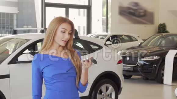 漂亮的幸福女人在经销商店里拿着新车钥匙视频的预览图