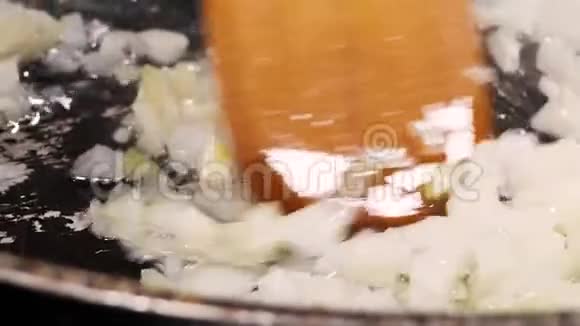 在平底锅中用油煎成细碎的洋葱视频的预览图