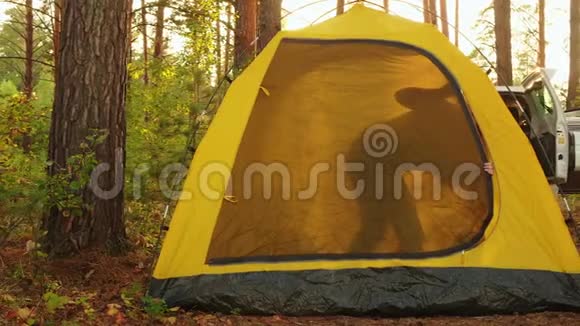 游客一家人在阳光明媚的森林里露营帐篷里醒来在露营地的背景日出中幸福的家庭视频的预览图