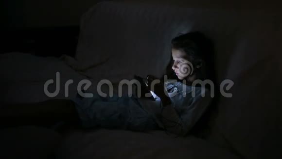 小女孩晚上用手机视频的预览图