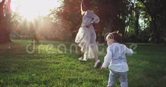 美丽的年轻家庭时尚打扮在一起玩在令人惊叹的公园中间他们两个小视频的预览图