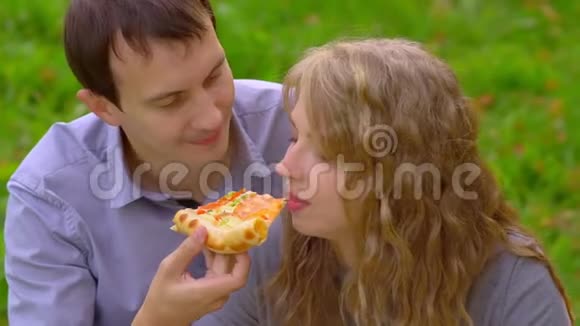 在公园里咬披萨的女孩视频的预览图