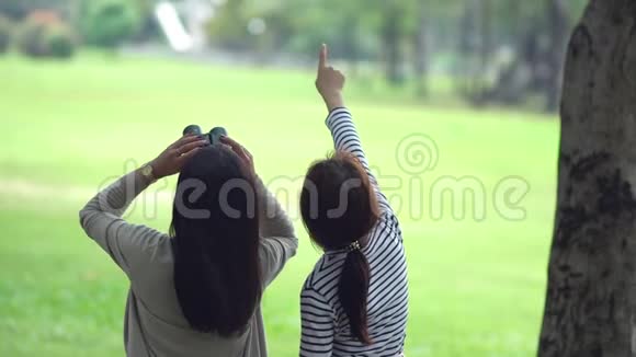 十几岁的女儿和漂亮的妈妈在公园里用望远镜视频的预览图