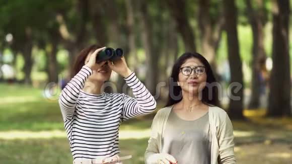 十几岁的女儿和漂亮的妈妈在公园里用望远镜视频的预览图