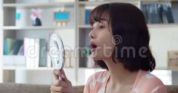 快乐微笑的亚洲年轻女子照镜子视频的预览图