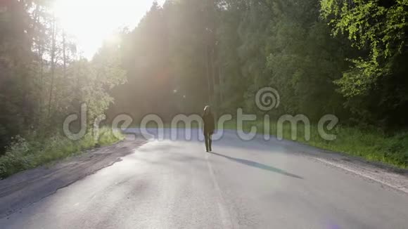 穿着黑色兜帽羊毛衫和太阳镜的白人走在路中间视频的预览图