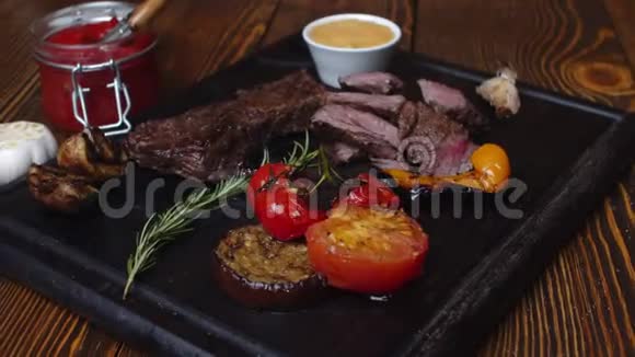 镜头沿着一排大理石牛肉烤蔬菜辛辣的肉酱和一根燃烧着的迷迭香枝视频的预览图