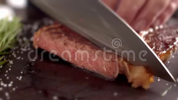 厨师用刀子割下牛排上的一块肉厨师切了一块牛肉牛排拿着一块视频的预览图